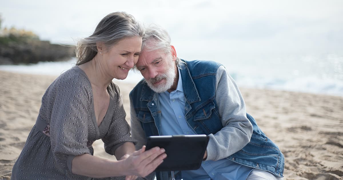 Retraités sur une tablette à la plage