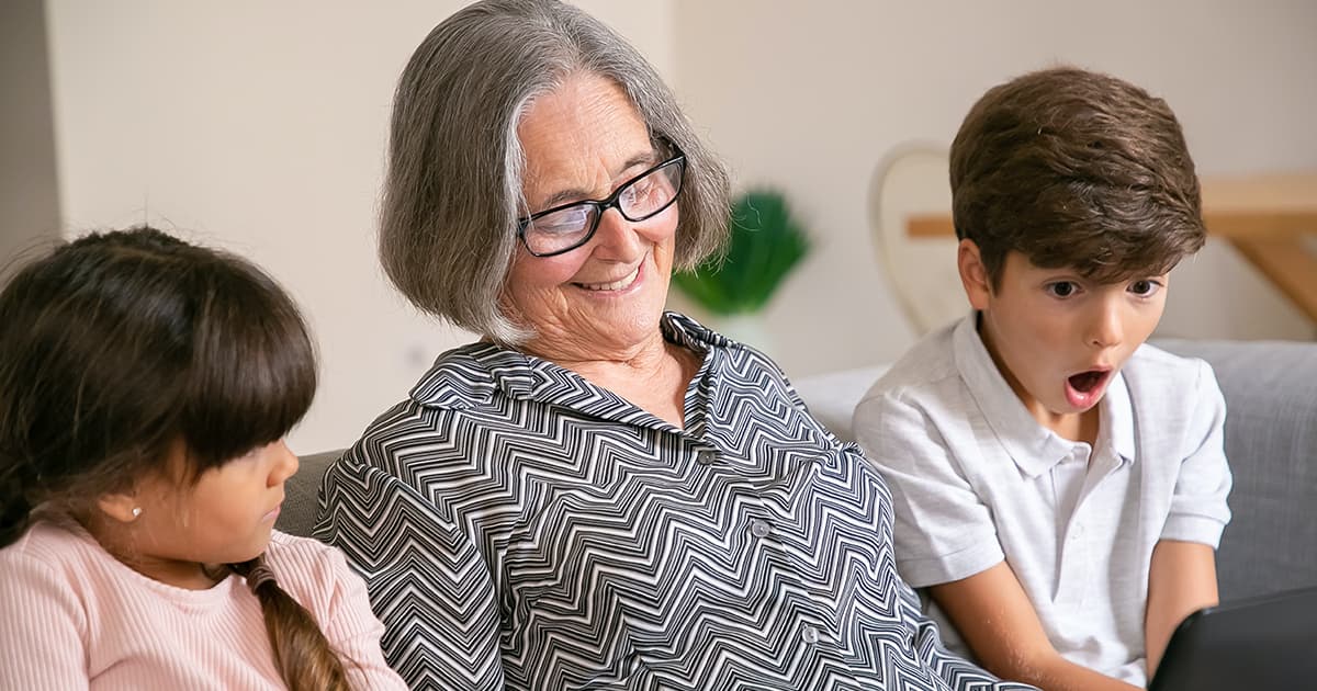 Grand mère avec ses petits enfants devant un ordinateur