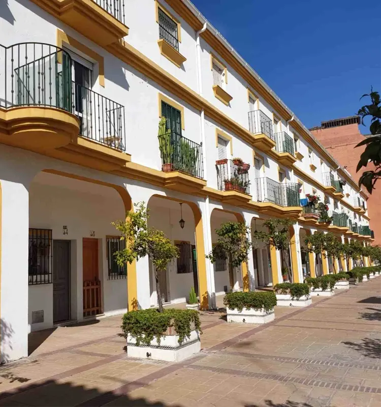 Rue résidentielle typique de Torremolinos, bordée de façades blanches et jaunes ornées de balcons et de végétation